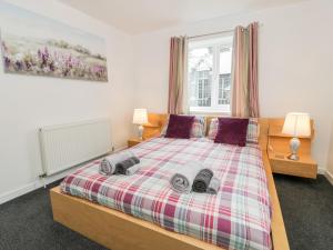 a bedroom with a bed with two towels on it at Ty Coch in Llanberis