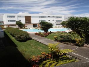 a building with a swimming pool in front of it at Hotel Ajavi in Ibarra