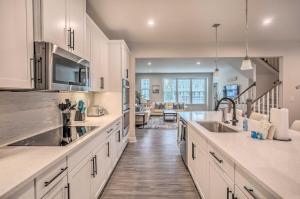 a kitchen with white cabinets and stainless steel appliances at N Myrtle Beach Townhome Near Barefoot Resort! in North Myrtle Beach