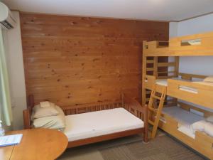 a room with two bunk beds and a table at Kencha Rumah in Hachijo