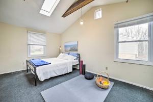 a bedroom with a bed and a table and two windows at Charming Vacation Rental 15 Mi to Pittsburgh in Monroeville
