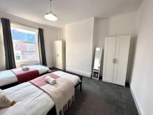 a hotel room with two beds and a window at 3 bedroom house near the city in Gateshead