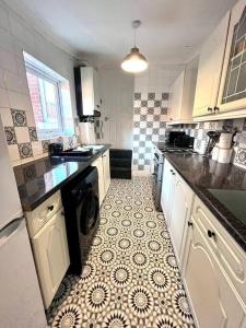 蓋茲黑德的住宿－3 bedroom house near the city，厨房配有洗衣机和烘干机,铺有瓷砖地板。