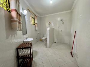 a white bathroom with a sink and a toilet at Charming Bungalows in Mwanza +29 photos