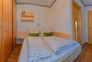 a bedroom with a large bed with green pillows at Appartment Lechner in Neukirchen am Großvenediger