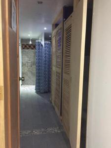 a hallway with wooden lockers in a room with a wall at Hostal Casa Pajaritos in Taxco de Alarcón