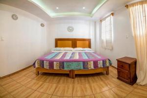 a bedroom with a bed and a wooden floor at Hostal Casa Pajaritos in Taxco de Alarcón