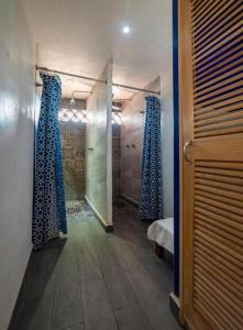 un pasillo con cortinas azules en una habitación con puerta en Hostal Casa Pajaritos en Taxco de Alarcón