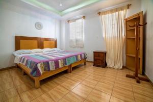 1 dormitorio con 1 cama y suelo de madera en Hostal Casa Pajaritos, en Taxco de Alarcón