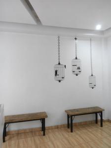 a room with two benches and hanging cages at Hostal Casa Pajaritos in Taxco de Alarcón +2 photos