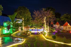 un patio del complejo con luces por la noche en Cat Ba Spring Garden Homestay, en Cat Ba
