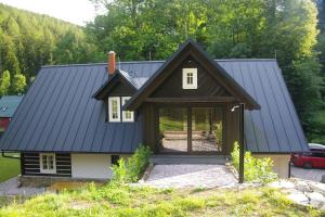 una casa con techo negro en Horská roubenka František Kvíz en Dolni Dvur