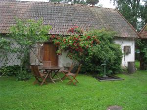 a table and chairs in front of a house with roses at Mariehem Logi in Sjöbo