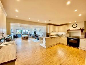 a large kitchen and living room with wooden floors at Elegant & spacious farmhouse with wonderful views in Penrith