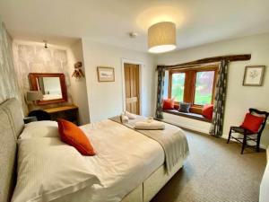 a bedroom with a large bed and a window at Elegant & spacious farmhouse with wonderful views in Penrith