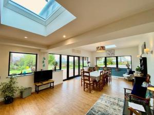 uma sala de estar com uma clarabóia, uma mesa e cadeiras em Elegant & spacious farmhouse with wonderful views em Penrith