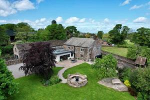 an aerial view of a large stone house with a yard at Elegant & spacious farmhouse with wonderful views in Penrith