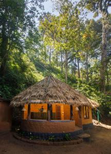 eine kleine Hütte mit Strohdach in der Unterkunft Ela Ecoland Nature Retreat in Munnar