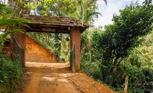 einen Eingang zu einer unbefestigten Straße mit einem Tor in der Unterkunft Ela Ecoland Nature Retreat in Munnar