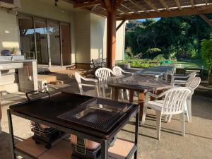 un patio con mesas, sillas y una parrilla en Kencha Rumah, en Hachijō