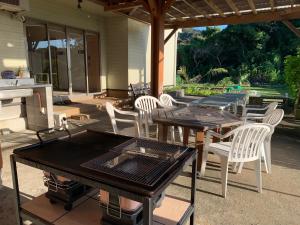 a patio with tables and chairs and a grill at Kencha Rumah in Hachijo