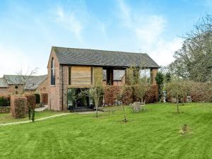 a house with a green yard in front of it at Olive in Kelsall