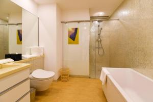 a bathroom with a tub and a toilet and a shower at The Clouds Apartment in Shenzhen