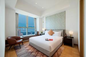 a hotel room with a bed and a desk and a chair at The Clouds Apartment in Shenzhen