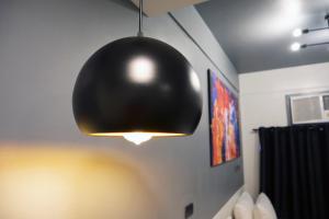 a black pendant light hanging from a room at mySTAY Hotel BGC West in Manila