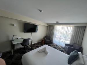 a hotel room with a bed and a desk and a television at The Gladstone in Gladstone