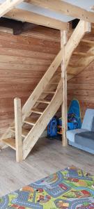 a loft bed in a wooden room with a bunk bed at Enklawa w Porębie in Długopole-Zdrój