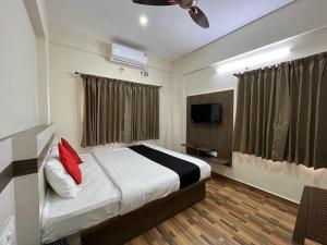 um quarto com uma cama e uma televisão de ecrã plano em Hotel JP Grand em Bangalore