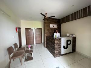 a man standing at a counter in a room at Hotel JP Grand in Bangalore