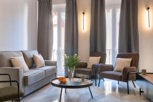 Magno Apartments San Gil - Shared Jacuzzi في إشبيلية: غرفة معيشة مع أريكة وكراسي وطاولة