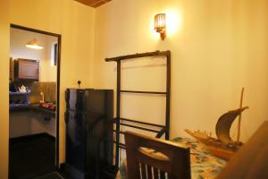 um quarto com um frigorífico, uma mesa e um espelho em Ruwan Jungle Homestay em Mirissa