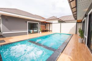 a swimming pool in the middle of a house at Don Teak Pool Villa Aonang Krabi in Ban Chong Phli