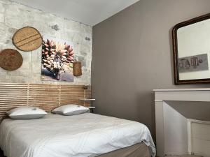 a bedroom with a bed with a stone wall at Appartement Saint Rémy de Provence in Saint-Rémy-de-Provence