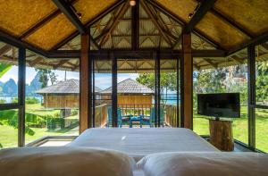 Tinidee Hideaway Tonsai Beach Krabi - SHA Extra Plus في شاطئ تونساي: غرفة نوم بسرير كبير فيها تلفزيون