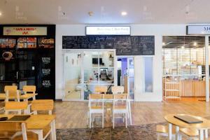 a restaurant with tables and chairs and a chalkboard on the wall at RedLiving Apartemen Serpong Green View - Hapukh Room Tower B in Ciater-hilir