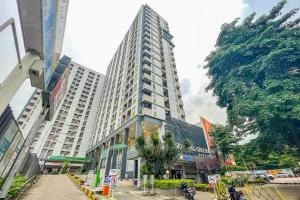 a tall building in the middle of a city at RedLiving Apartemen Serpong Green View - Hapukh Room Tower B in Ciater-hilir