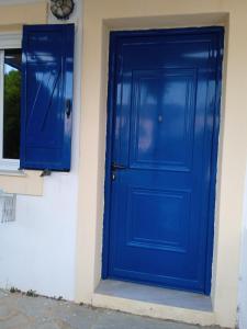 a blue door on the side of a building at Kouvaras Apartments in Kythira