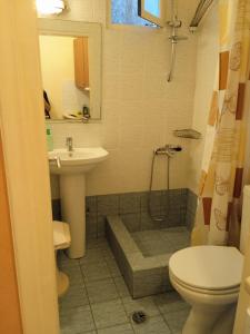 a bathroom with a sink and a toilet and a shower at Kouvaras Apartments in Kýthira