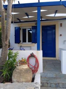 基席拉的住宿－Kouvaras Apartments，一座有蓝色门和红色软管的房子