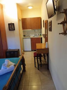 a room with a bed and a table and a kitchen at Kouvaras Apartments in Kythira