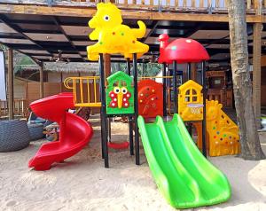 a playground with a slide in the sand at Cola Goa Beach Resort in Cola