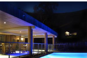 a house with a swimming pool at night at Betikure Parc Lodge in Bourail