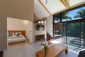 a bedroom with a bed and a large window at Betikure Parc Lodge in Bourail