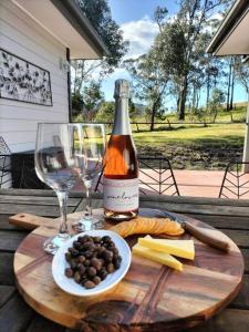 a bottle of wine and a plate of food and a glass at Lambs Valley Guest House. in Lambs Valley