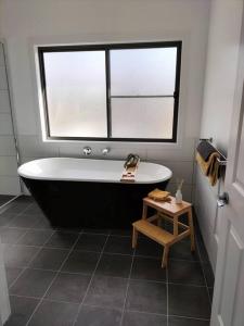 a bath tub in a bathroom with a window at Lambs Valley Guest House. in Lambs Valley