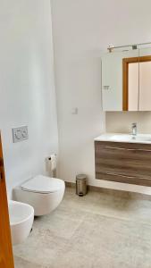 a white bathroom with a toilet and a sink at Casa Penina in Portimão